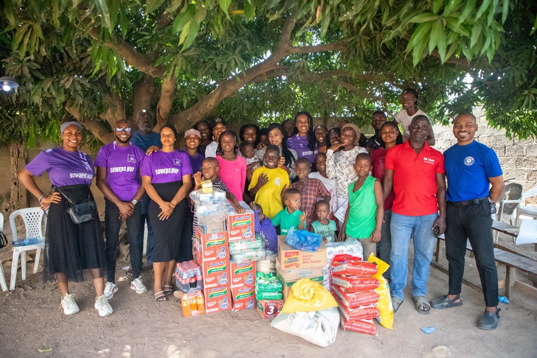 The SowersHub team with children and staff at an orphanage, beside provisions brought for the home