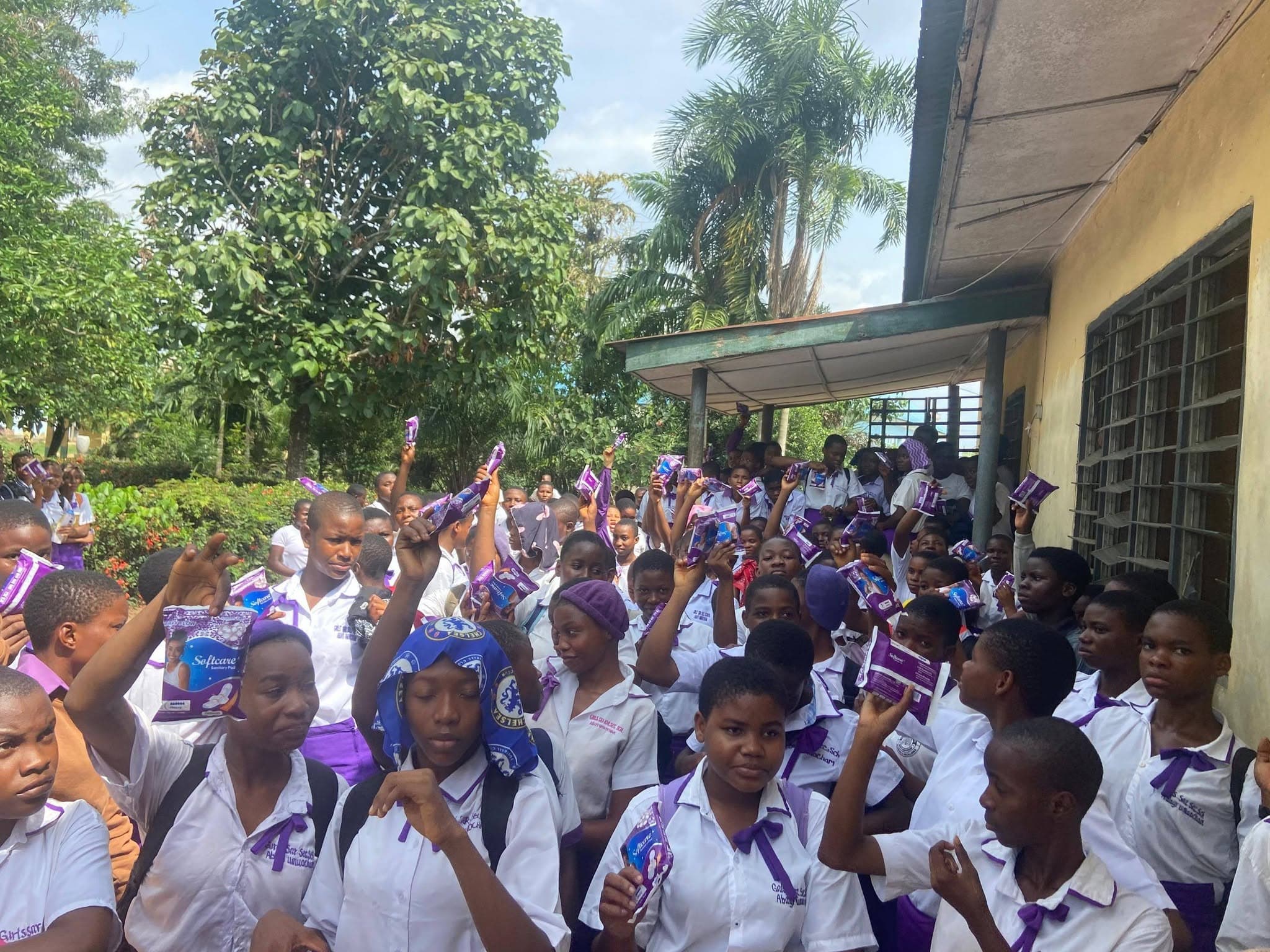Schoolgirls holding up sanitary pads received through the Pad a Girl Child project